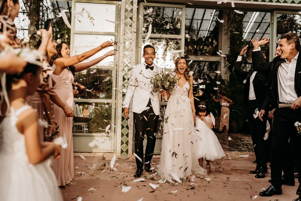 Happy newly married couple surrounded by their friends and family after the wedding ceremony.